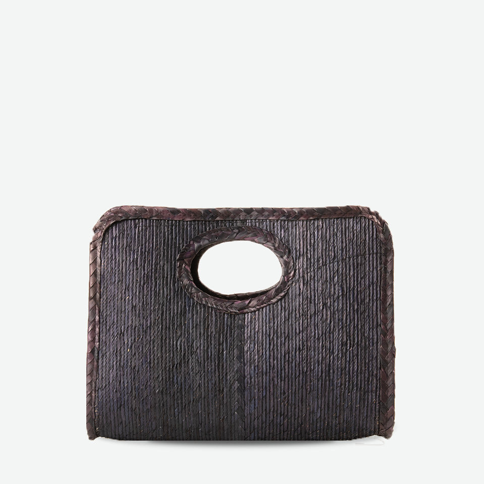 Mini square handheld straw tote in black and natural, woven from palm and dyed with organic colors. Summer-ready design by Per Lei New York.
