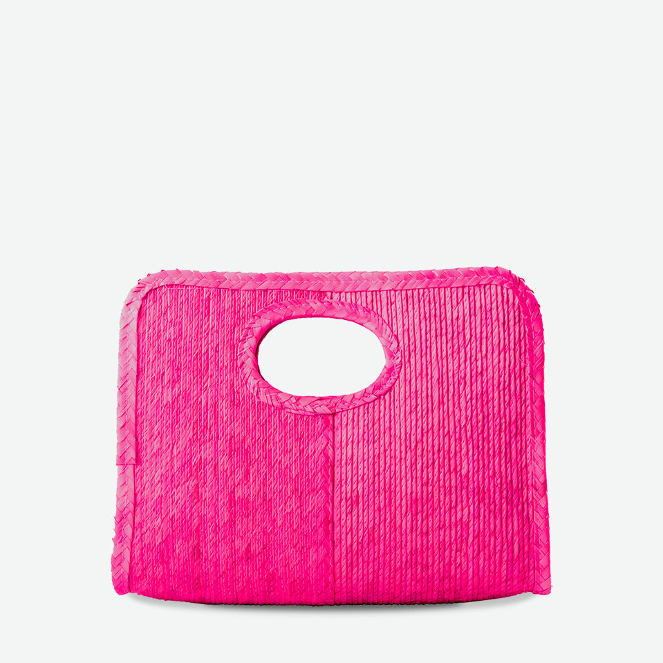 Mini square handheld straw tote in fuchsia, woven from palm and dyed with organic colors. Summer-ready design by Per Lei New York.