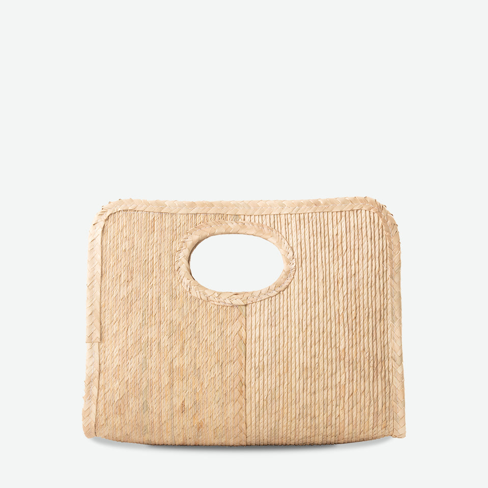 Mini square handheld straw tote in natural, woven from palm and dyed with organic colors. Summer-ready design by Per Lei New York.