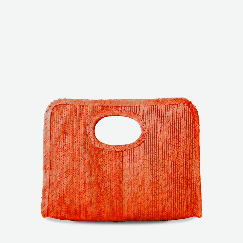 Mini square handheld straw tote in orange, woven from palm and dyed with organic colors. Summer-ready design by Per Lei New York.
