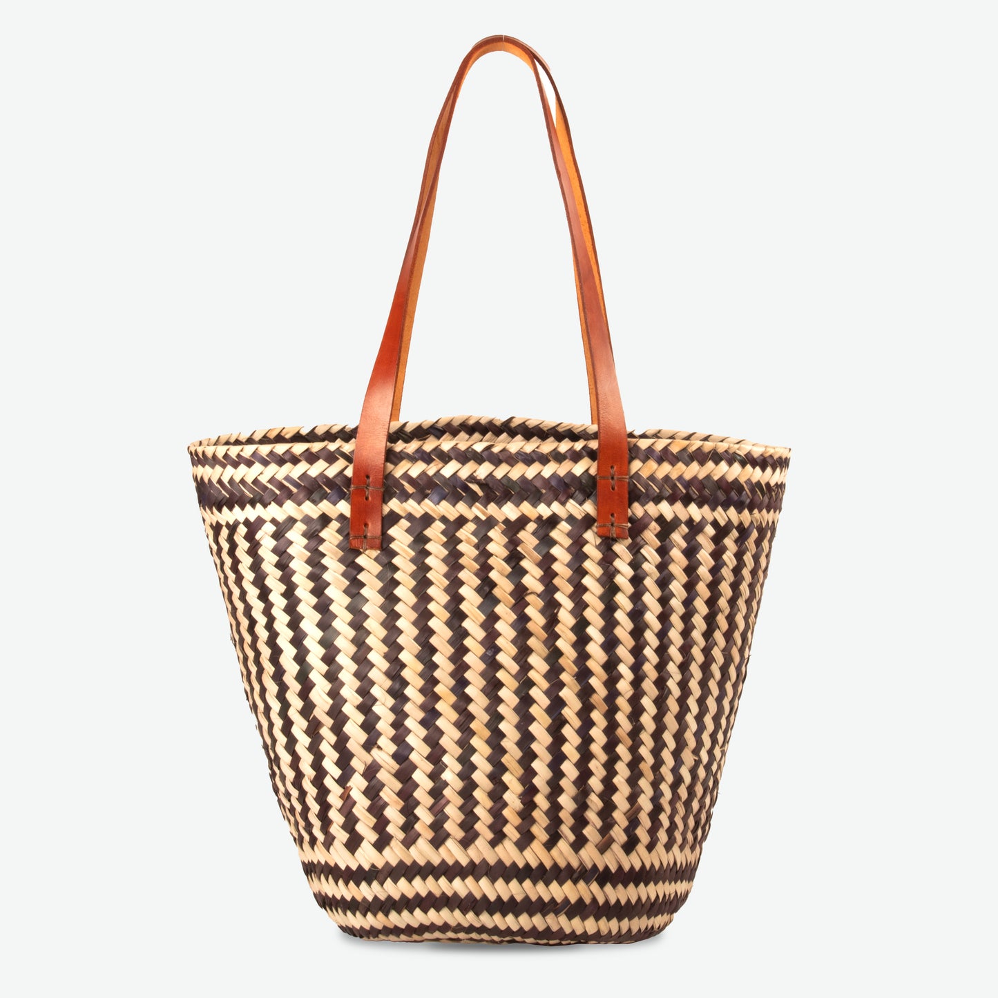 Black and white handwoven straw tote with circular straw handles, featuring a structured silhouette against a plain background.