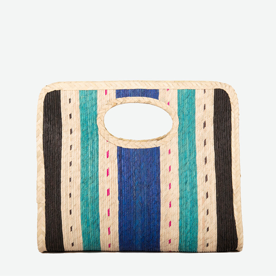 Square straw beach tote in blue and teal, woven from palm and dyed with organic colors. Summer-ready design by Per Lei New York.