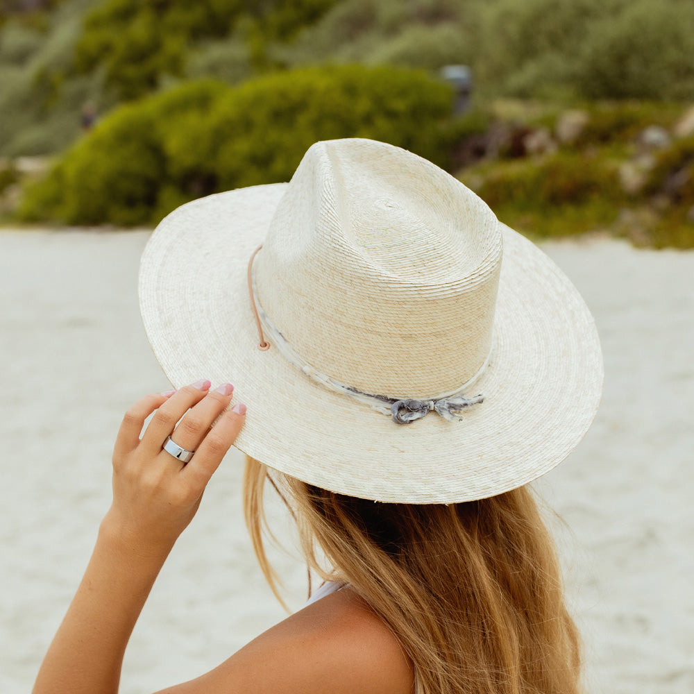 Person wearing a straw hat on a beach